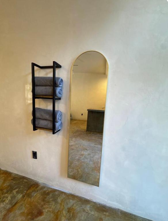 a mirror in a room with a white wall at Coyote Room in Arteaga