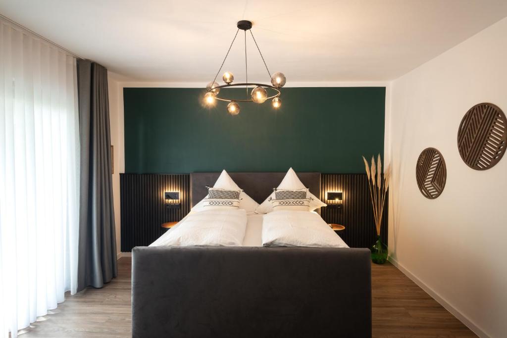 a bedroom with a black bed with white pillows at Moselweingut & Gästehaus Hubertushof in Trittenheim