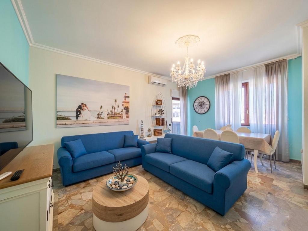 a living room with blue couches and a table at Appartamento Miramare in Follonica
