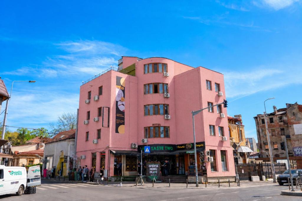 a pink building on the corner of a street at Occidental Wise Transit in Bucharest