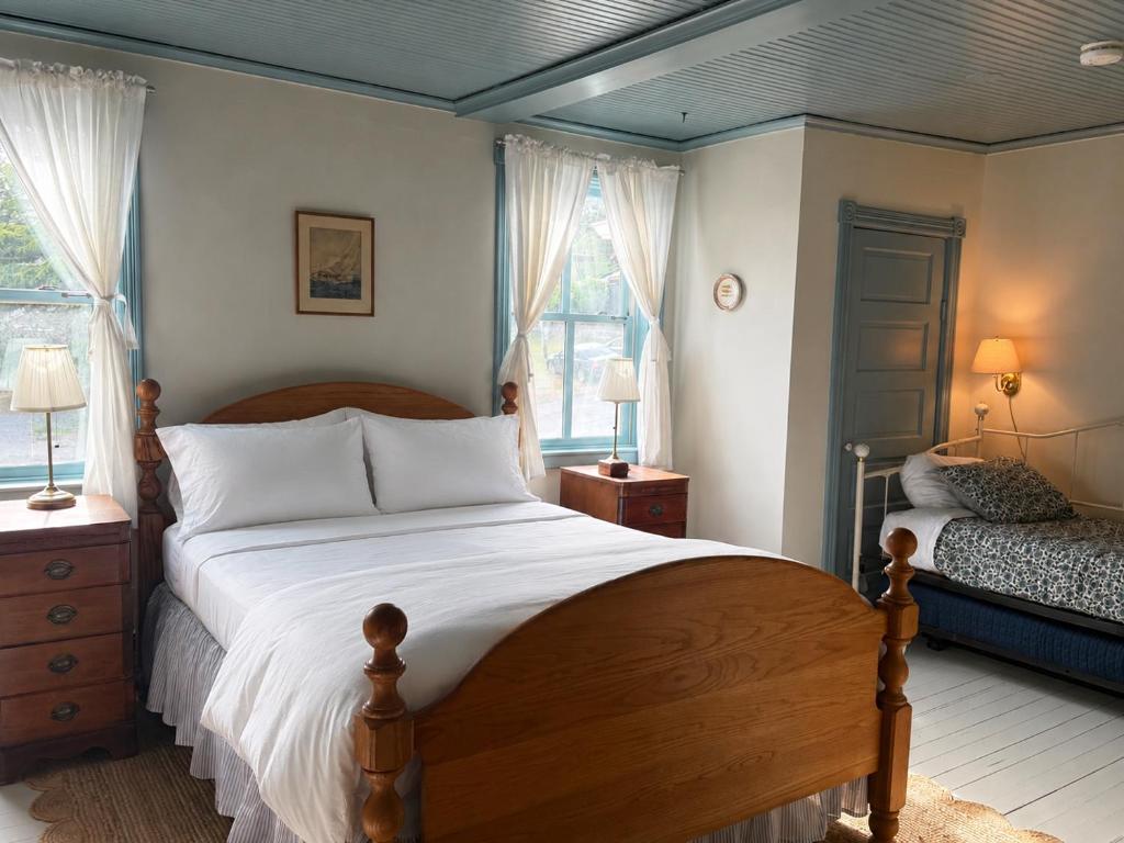 a bedroom with a large bed and two windows at Orcas Hotel in Orcas