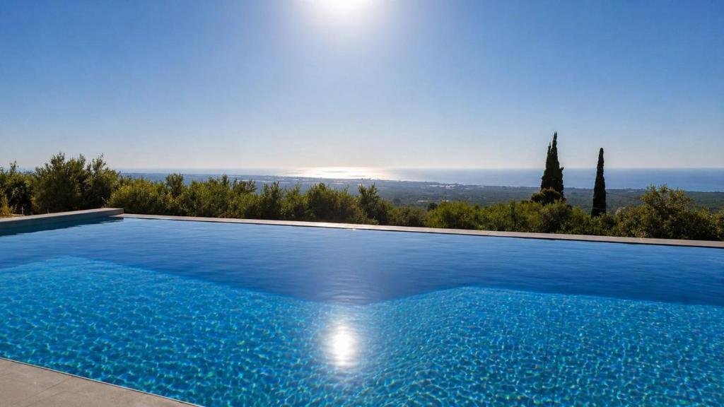 a swimming pool with a view of the ocean at Villa Palomar in Kyparissia