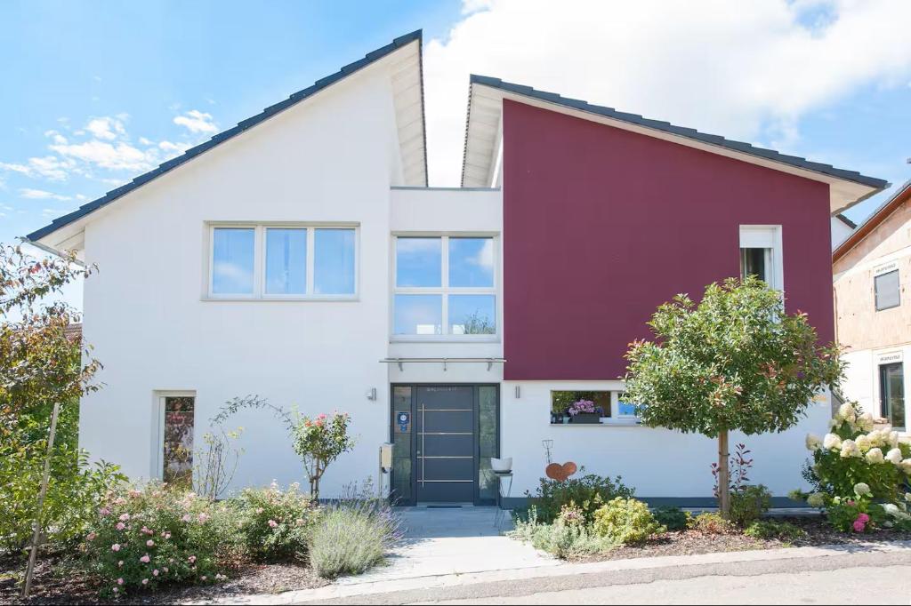 a white and red house with a black door at Am Bienenfeld in Ettenheim