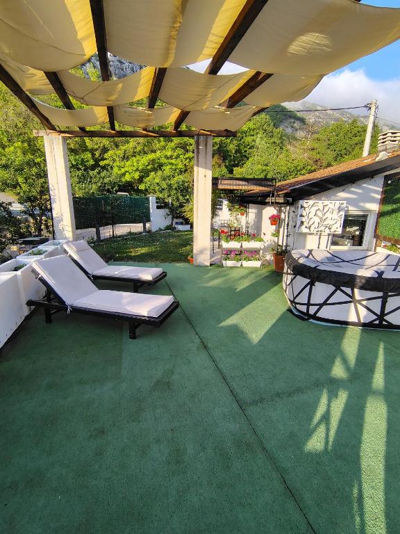a patio with two lounge chairs and a table at Tara Lapčići Budva in Budva