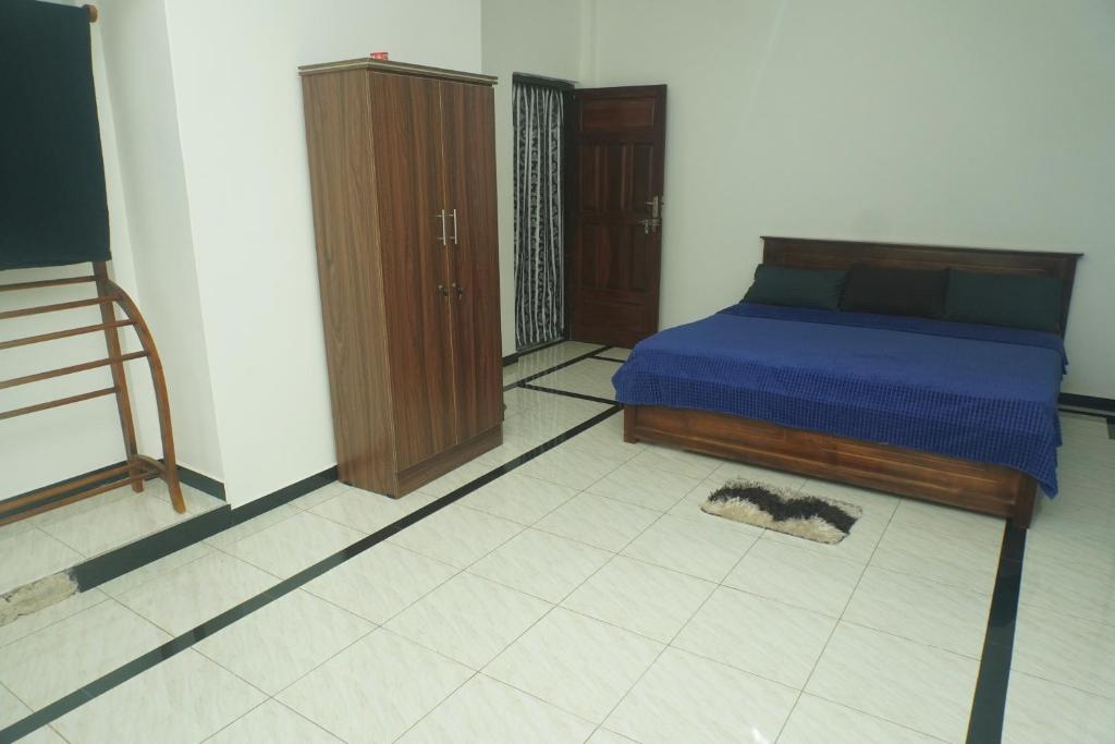 a bedroom with a bed and a cabinet and a rug at T-Nova Guest House in Trincomalee