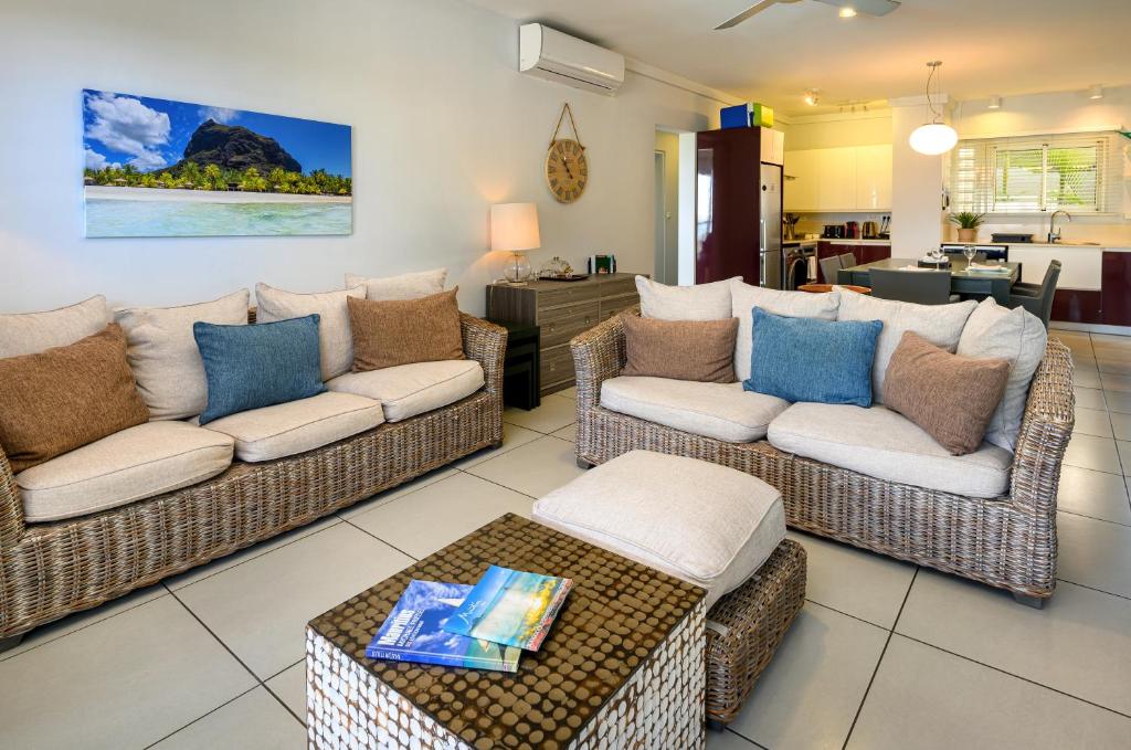 a living room with two couches and a table at Plage Bleue D2 in Trou aux Biches