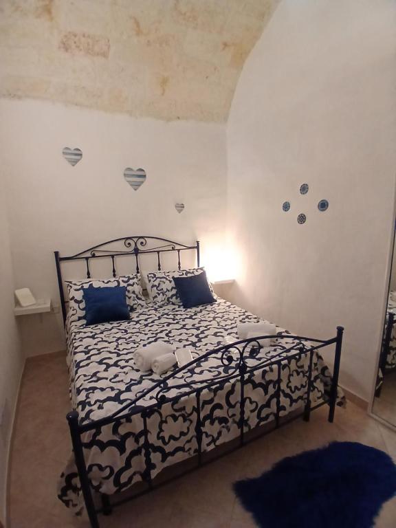 a bedroom with a black bed with blue pillows at Maison della Madia in Triggiano