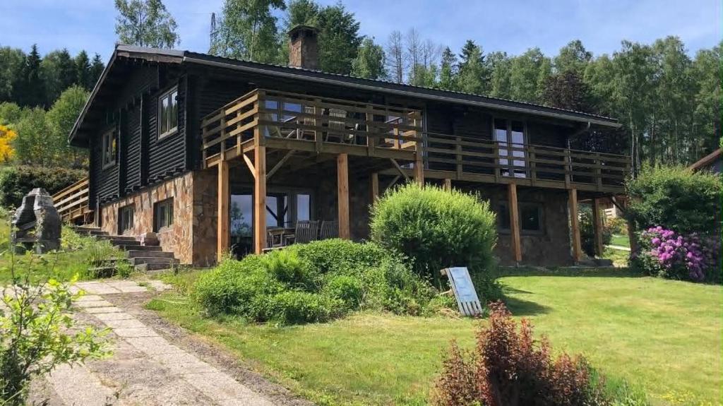 a large log cabin with a grass yard at Le Caroline du Nord in Tenneville