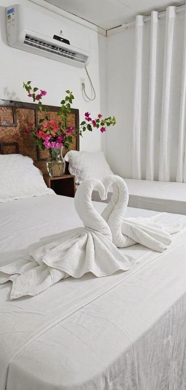 two swans forming a heart on a white bed at Estresse Zero in Atins