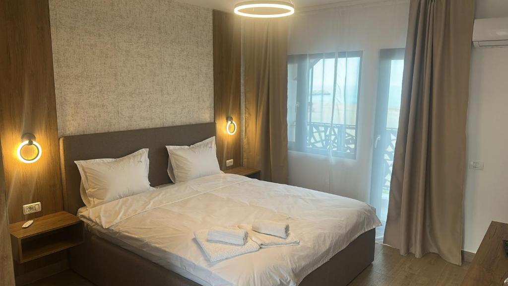 a bedroom with a bed with two towels on it at Vila DVG Costinesti in Costinesti