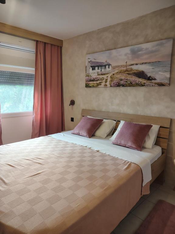a bedroom with a bed with a painting on the wall at Jelena Lapčići Budva in Budva