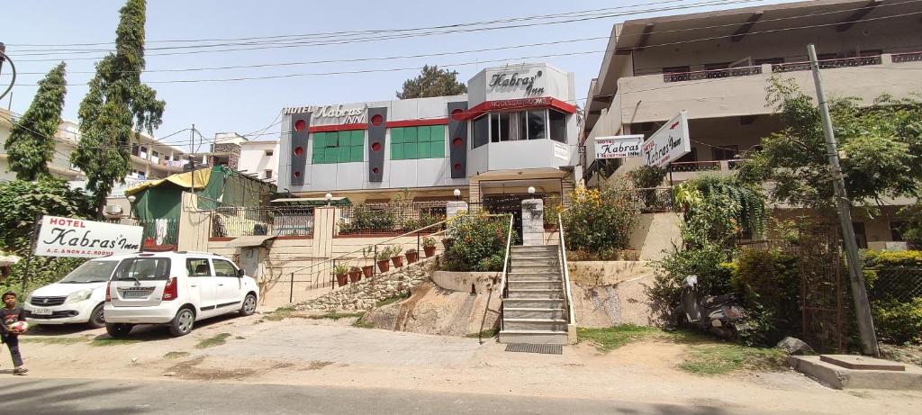 a white car parked in front of a building at Hotel kabras' inn in Mount Ābu