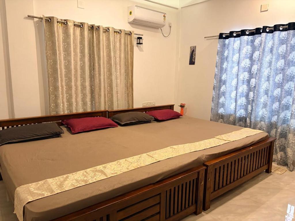a large bed in a room with curtains at Ira Wanderlust Homes & Tours in Trichūr
