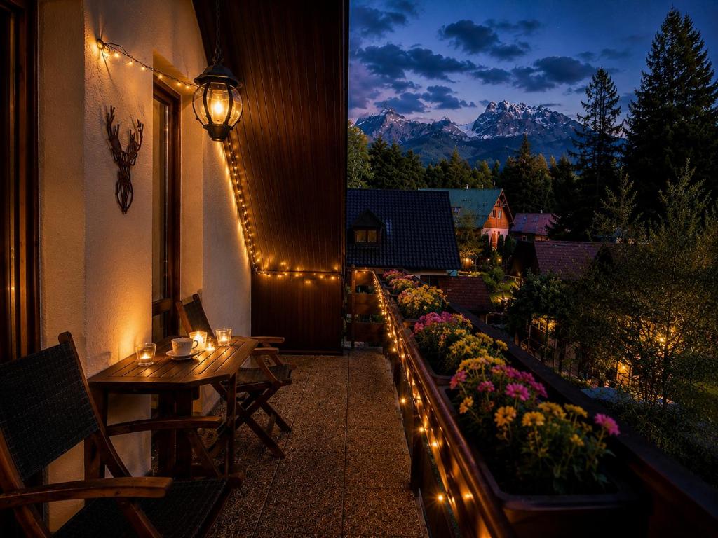 a patio with a table and chairs and lights at Mezonet Tatry in Vyšné Hágy