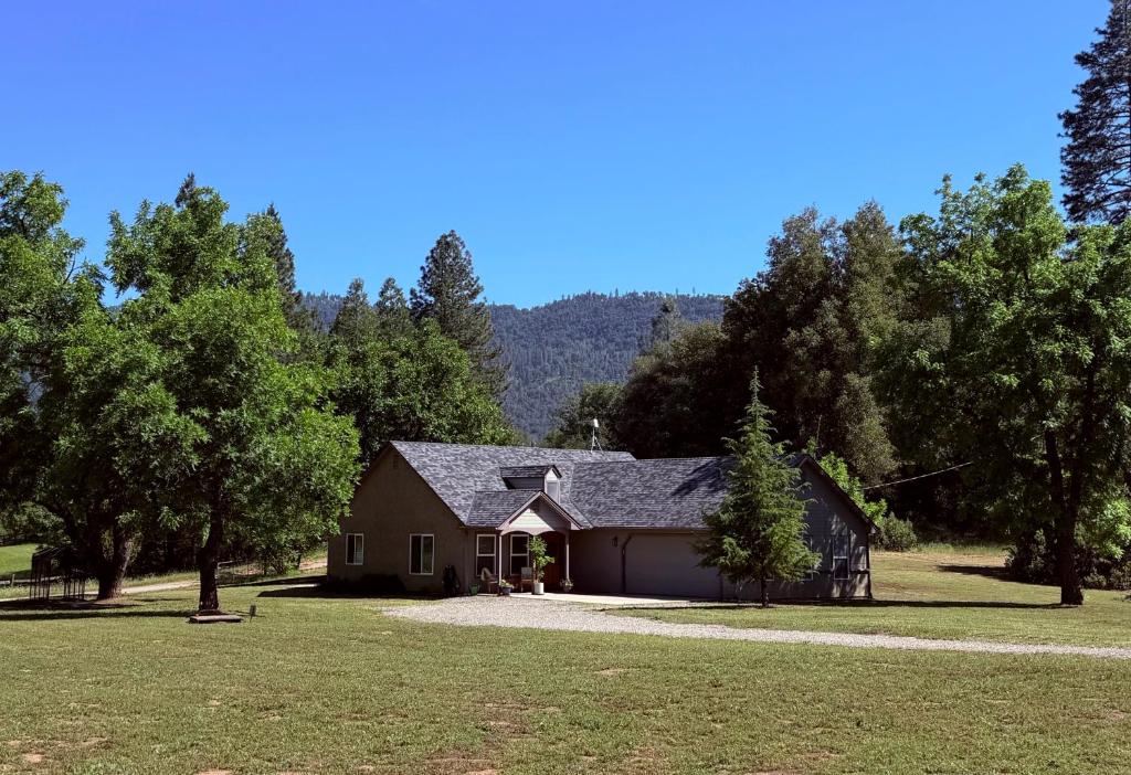 a house with a garage in a field with trees at Walnut Grove 2BD 1Bath in Oakhurst