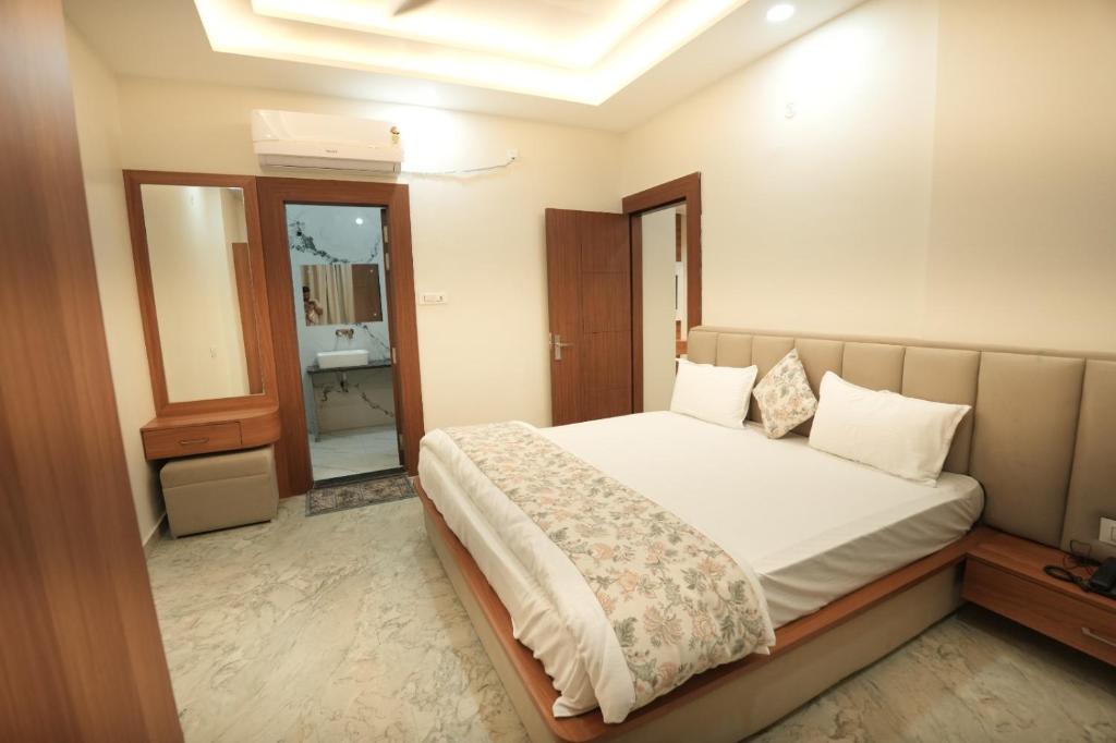 a bedroom with a large bed and a bathroom at Hotel Chanda in Jhānsi