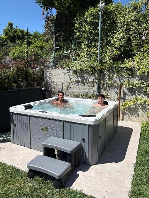 two people in a jacuzzi in a yard at Holiday Apartments Campoverde in Salò