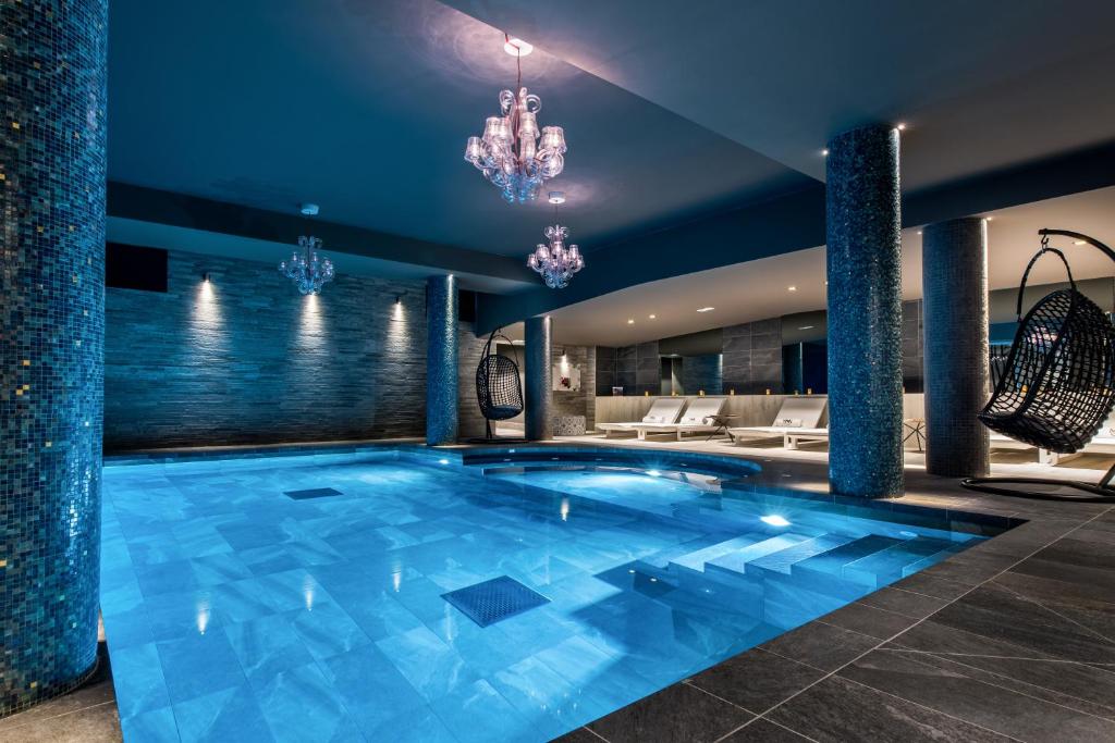 a large swimming pool in a hotel room with a chandelier at Chalet Skadi - Village Montana in Val dʼIsère