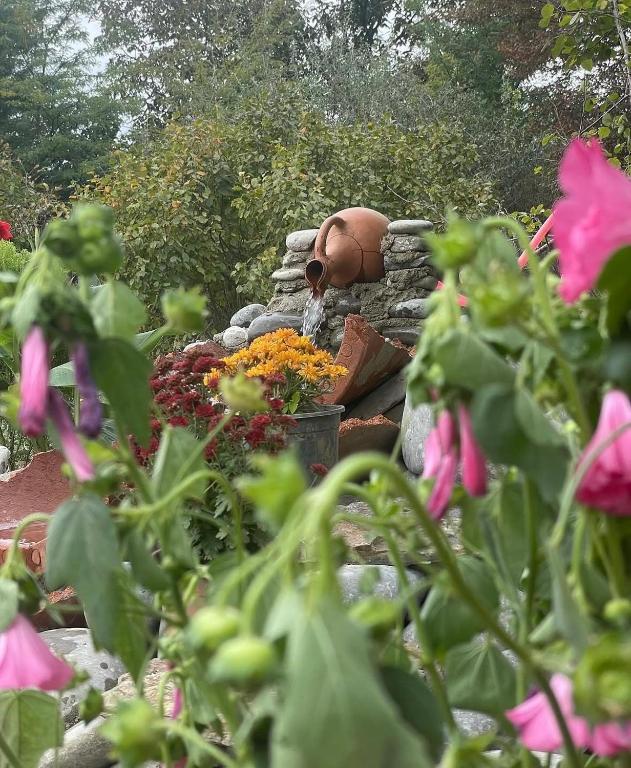 a statue of a person sitting on a bench with flowers at Uplistsikhis saamo in Kʼvakhvreli