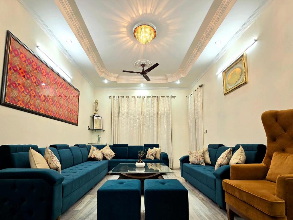 a living room with blue couches and a ceiling at Kanwar Homestay in Amritsar
