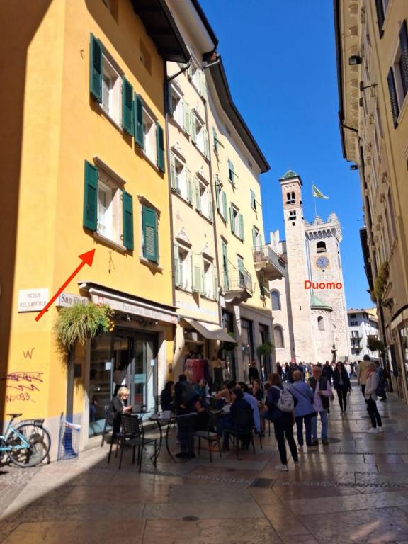 a group of people walking down a city street at Vicolo al Duomo in Trento
