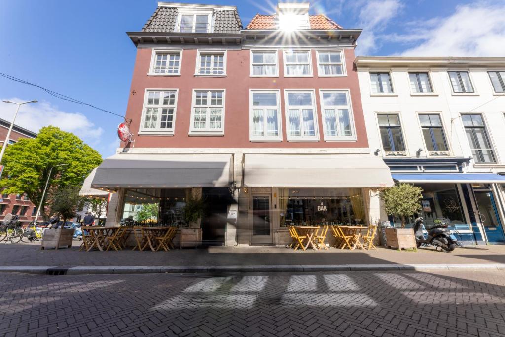 a building with tables and chairs in front of it at EL HOTEL - The Hague in The Hague