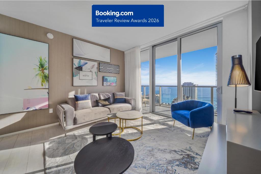 a living room with a couch and a blue chair at Wake Up To Ocean Views - Stunning 2BDR & 2BA Condo STEPS AWAY FROM THE OCEAN, NO RESORT & PARKING FEES, CHECK DETAILS in Hollywood