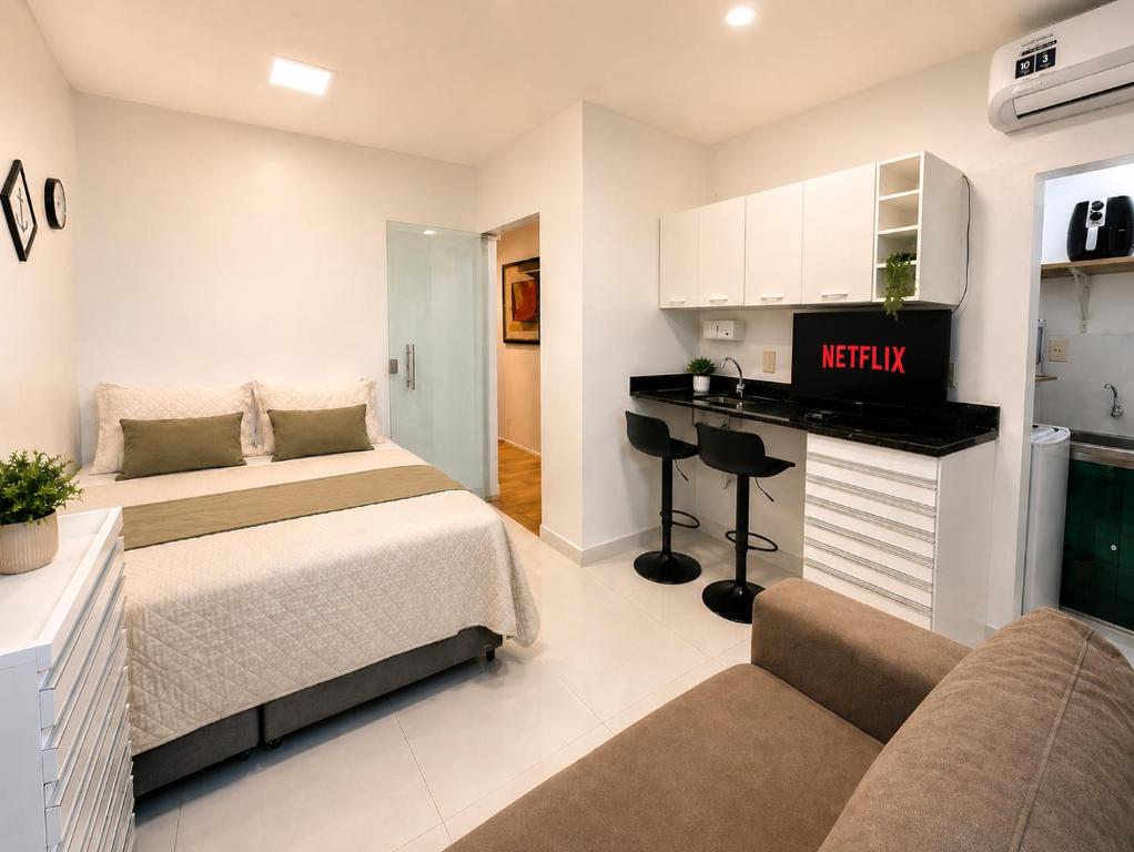 a bedroom with two beds and a desk in it at Studio no Centro com Wi-Fi in Manaus