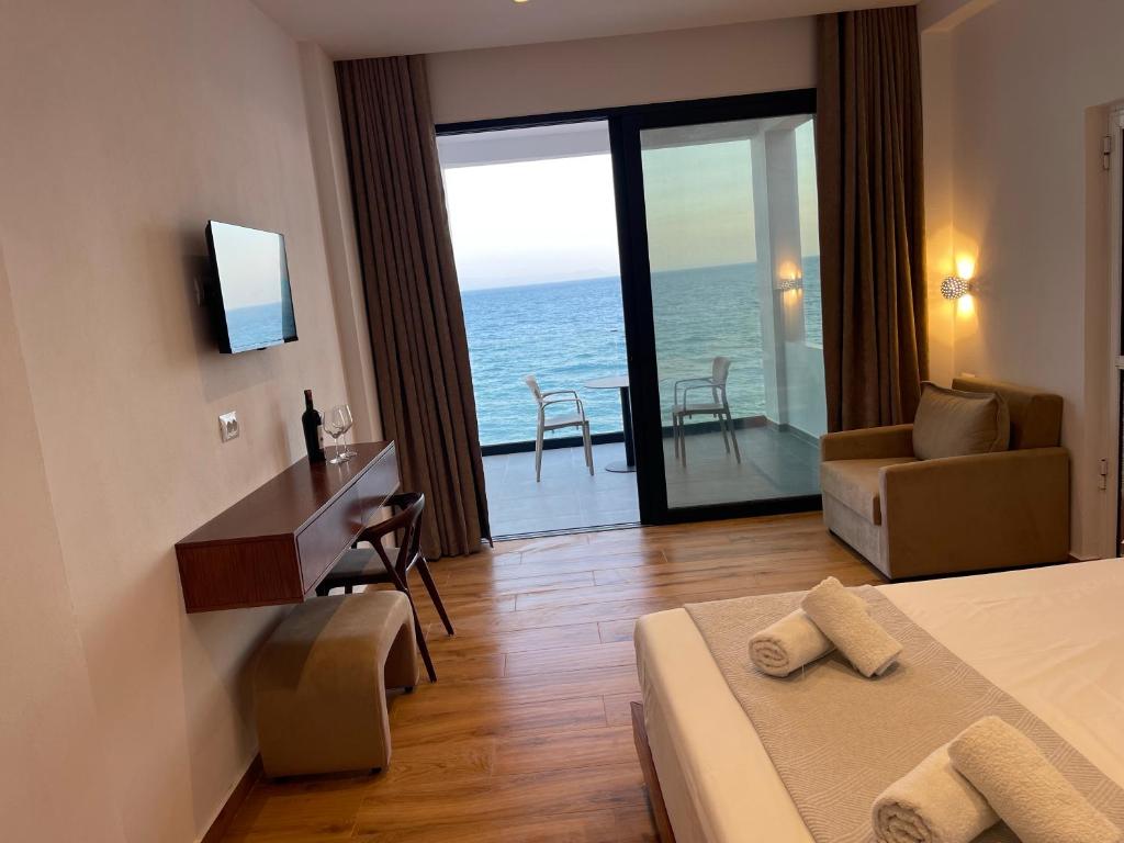 a hotel room with a bed and a view of the ocean at Villa Scorpio in Qeparo