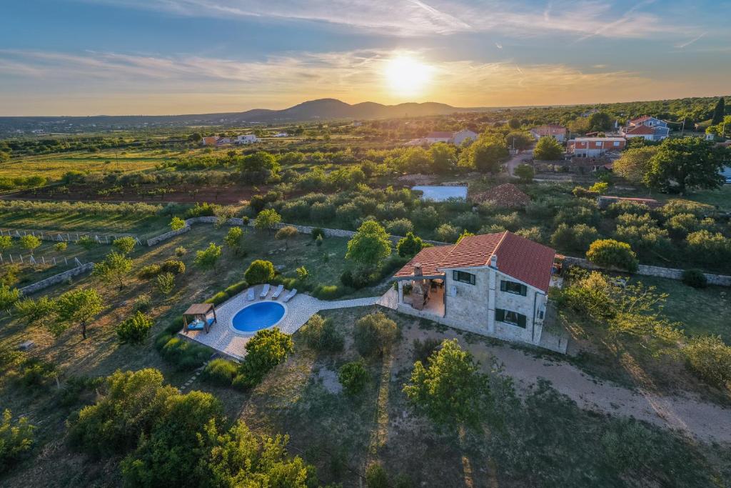 an aerial view of a house with a swimming pool at Villa Stone Pearl with heated swimming pool in Sveti Filip i Jakov