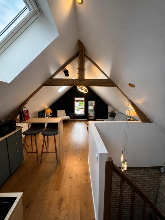 an attic room with a table and chairs in it at Le nid de Bertille in Le Vaudreuil