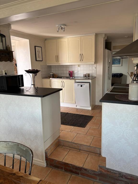a kitchen with white cabinets and black counter tops at Casa utsikten in Uddevalla