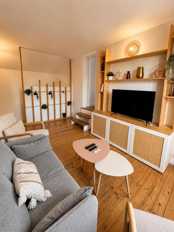 a living room with a couch and a tv at La Petite Luce in Le Vaudreuil