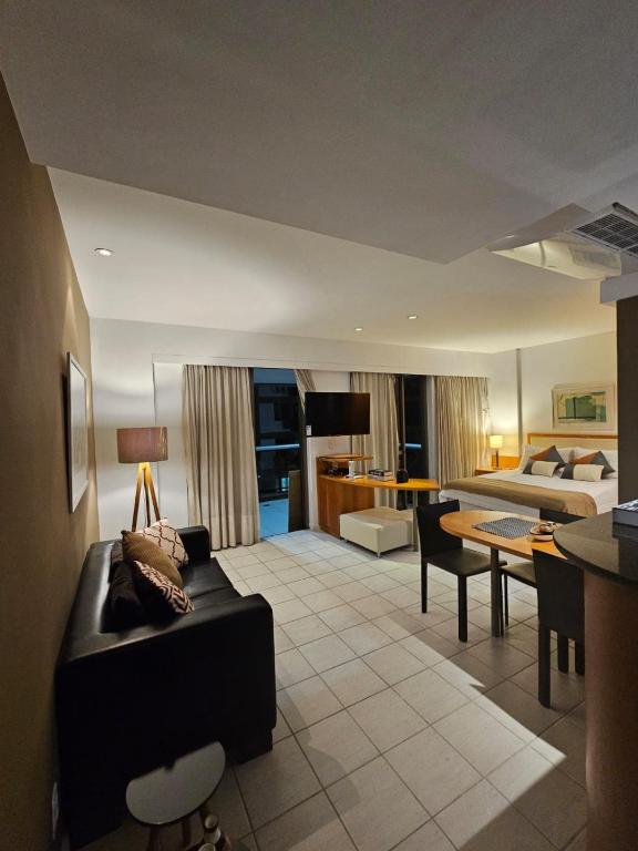 a living room with a couch and a bed at Flat na praia da Barra 2 in Rio de Janeiro