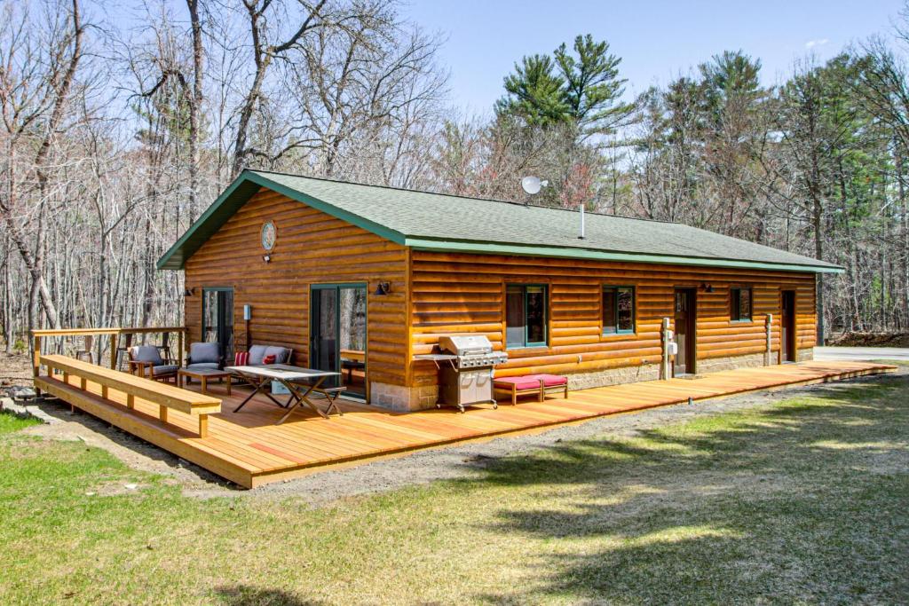 a log cabin with a deck and a grill at Long Lake Cabin w/ Dock: Fish & Hike! in Walker
