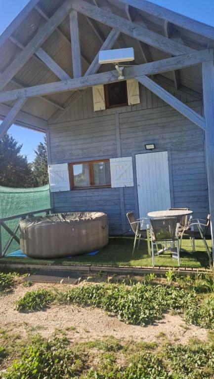 a house with a tub and a table and chairs at Chalet à la campagne 40m2 in Charleval