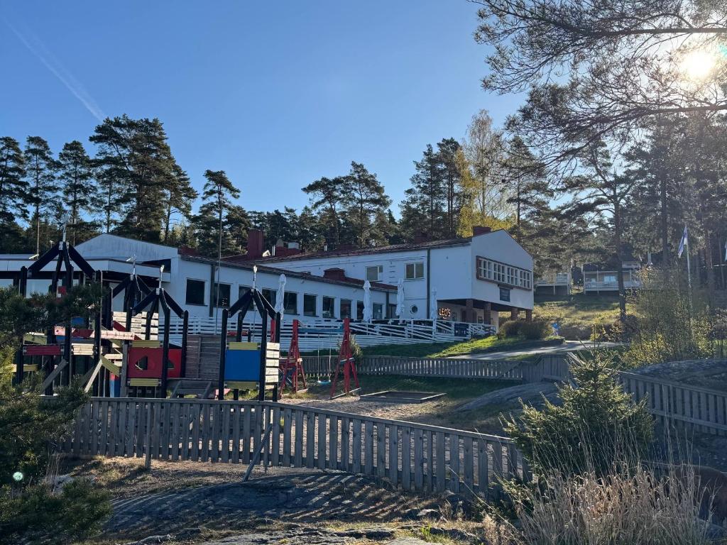 a playground in front of a white building at Hotel Airisto Marina in Pargas