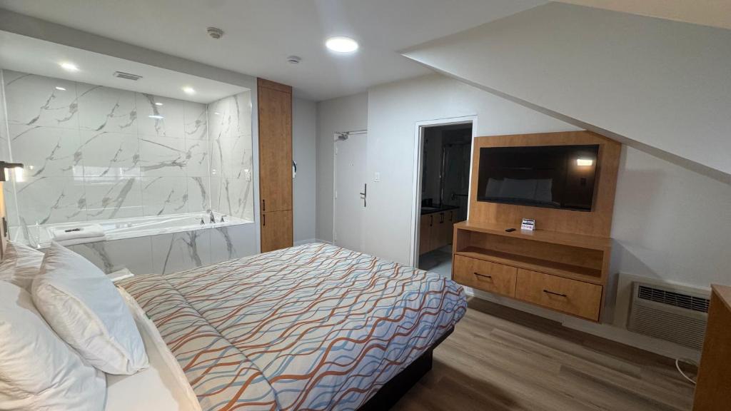 a bedroom with a bed and a sink and a tv at Super 5 Inn in Mississauga
