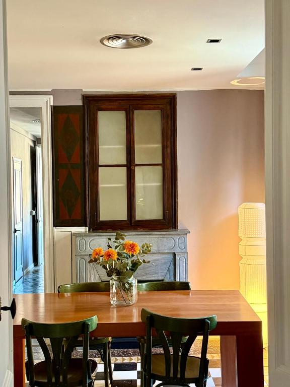 a dining room table with chairs and a vase of flowers at Rambla Riverview in Girona