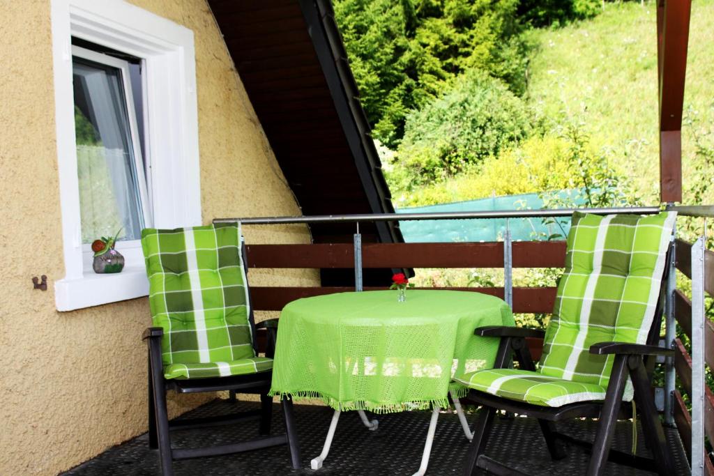 a green table and chairs on a balcony at Beim Andi in Stockach