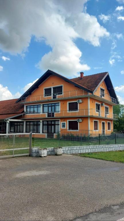 an orange building with a fence in front of it at Zdravo Homolje in Petrovac na Mlavi