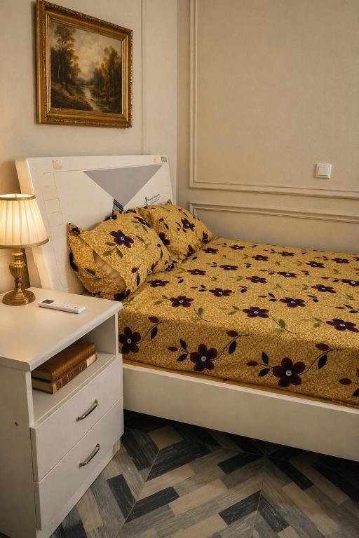 a bedroom with a bed and a nightstand with a lamp at Cj apartment kasoa in Kasoa