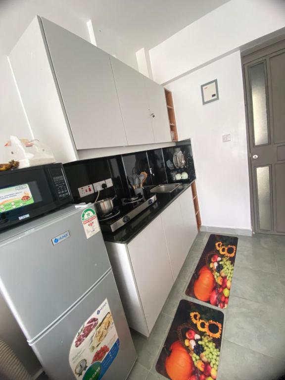 a kitchen with a refrigerator and a stove top oven at CozMila homes in Kiambu