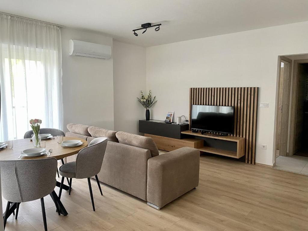 a living room with a couch and a table at Green Nest Apartment in Sárvár