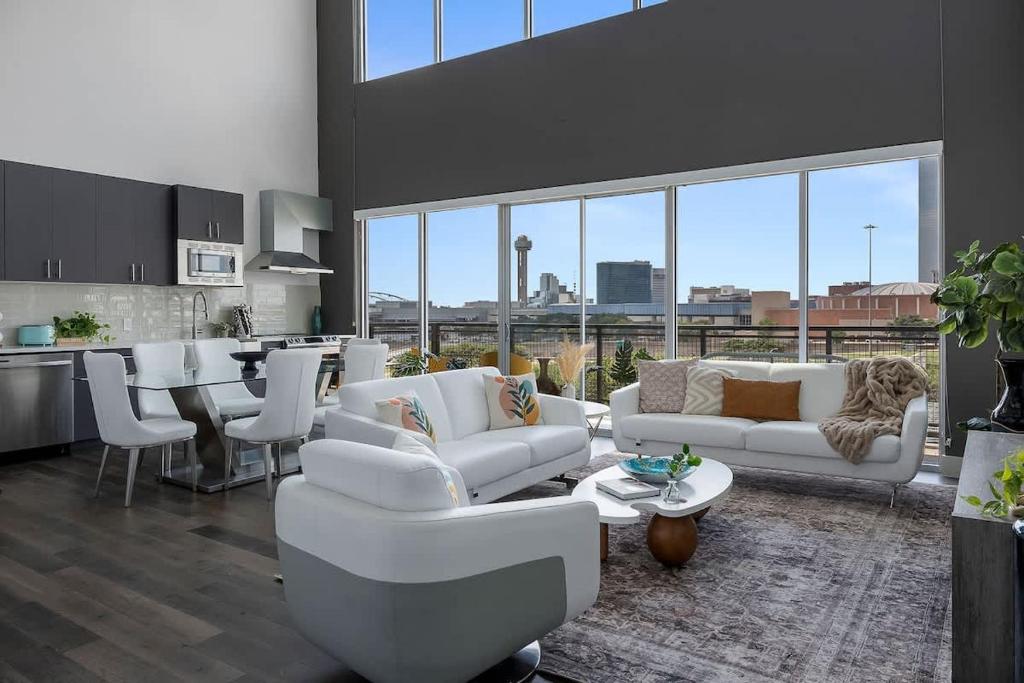 a living room with white couches and a kitchen at Penthouse Dallas no 603 in Dallas