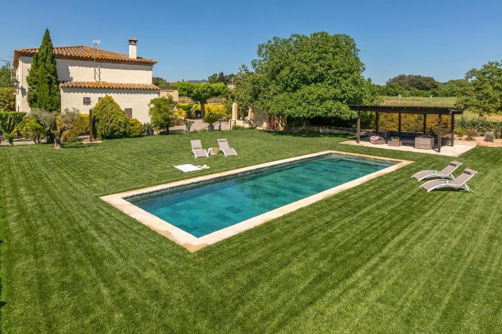 a large yard with a swimming pool and a house at Can Cristus in Monells