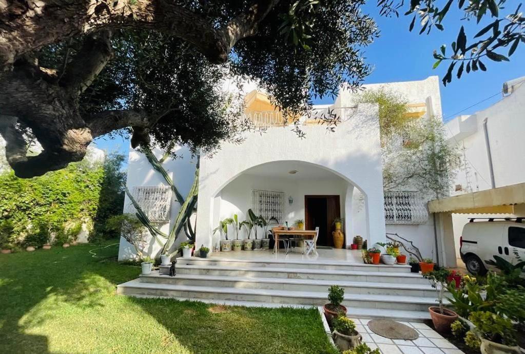 a white house with a table and chairs in a yard at Villa Jasmin in Hammamet