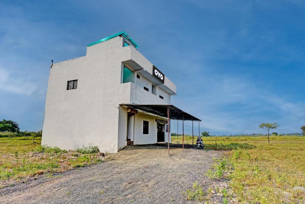 a building with a sign on it in a field at Hotel O RJ HOTEL INN in Pānchgaon