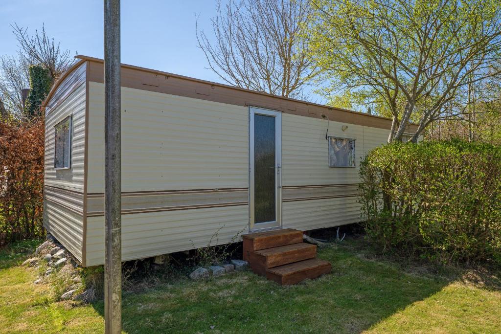 a tiny house with a porch and a window at Alte Dorfstraße 29 REETungsring in Behrensdorf