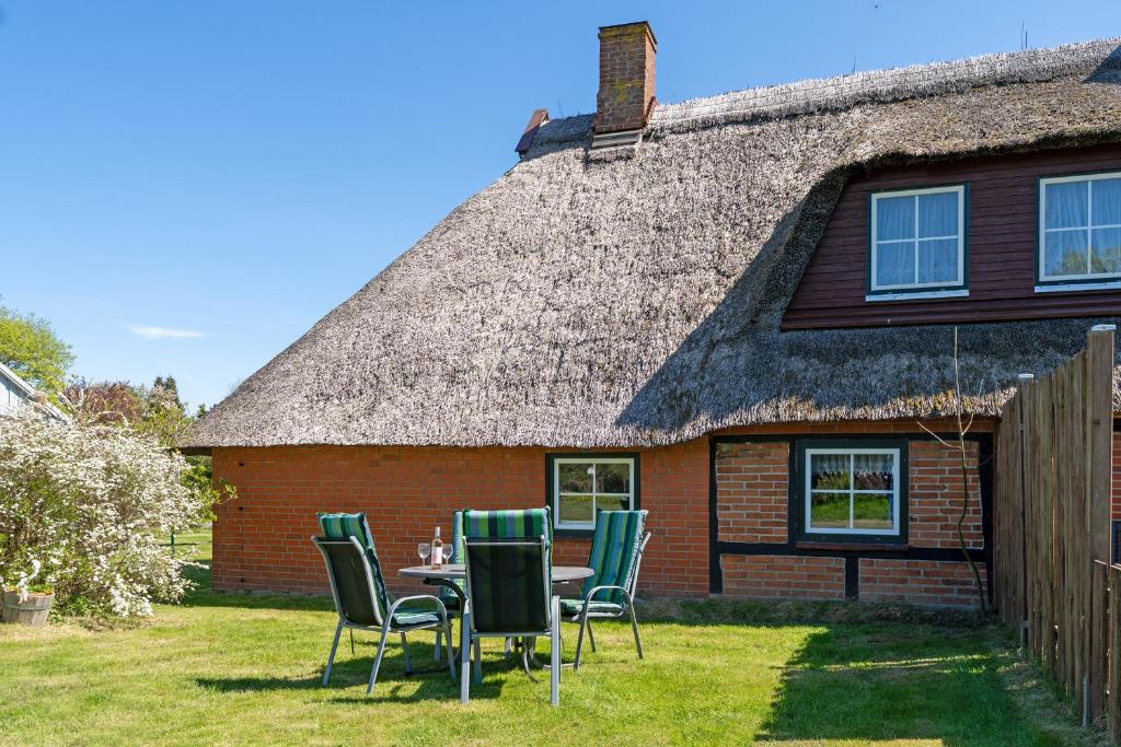 a table and chairs in front of a house at Alte Dorfstraße 29 REETungsboot in Behrensdorf